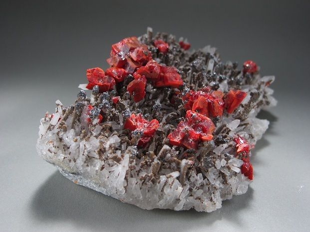 Red and lustrous crystals ofrealgar on a field of sharp, lustrous